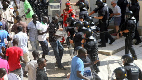 La policía carga contra los compañeros del inmigrante fallecido, que intentaban evitar el traslado de su cuerpo. EFE/Jaume Sellart