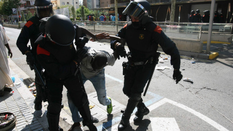 Miembros de los Mossos d'Esquadra se llevan a un participante en los disturbios que han tenido lugar hoy en Salou. EFE/Jaume Sellart