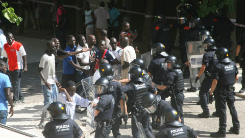 Los compañeros del senegalés fallecido esta mañana increpan a los Mossos, que han respondido con cargas. EFE/Jaume Sellart