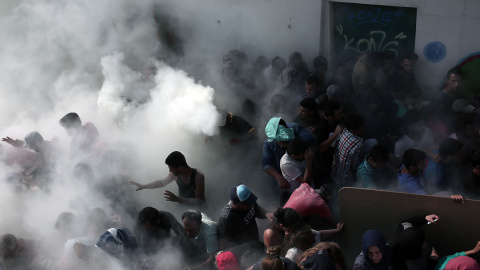 Cientos de inmigrantes son rociados con extintores por la policía en el los enfrentamientos en el estadio donde se llevaba a cabo un procedimiento de registro, en la isla griega de Cos, el 11 de agosto de 2015. AFP / ANGELOS TZORTZINIS