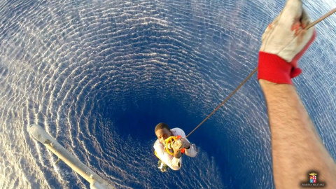Un emigrante es rescatado por un helicóptero de la marina de guerra italiana en la zona donde su barco se hundió en el Mar Mediterráneo ayer. REUTERS