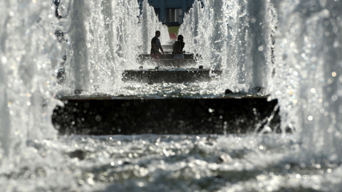 Una pareja pasa por unas fuentes en el centro de Moscú, Rusia, el 12 de agosto de 2015. AFP PHOTO / VASILY MAXIMOV