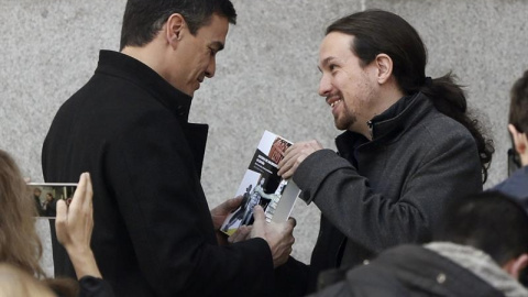 El momento en el que Pablo Iglesas entrega el libro a Pedro Sánchez antes de su reunión. EFE/J. J. Guillén