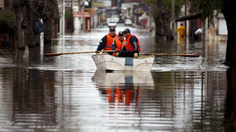 Policías argentinos patrullan una calle inundada en un barco en Luján, Argentina. Más de 20.000 personas han sido evacuadas después de las lluvias torrenciales en el último fin de semana que causaron inundaciones en el norte de la provincia