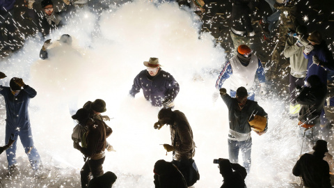 Participantes en la "guerra de carretillas" esta noche en las calles de Elche, durante la tradicional Nit del Albà. EFE / Manuel Lorenzo.