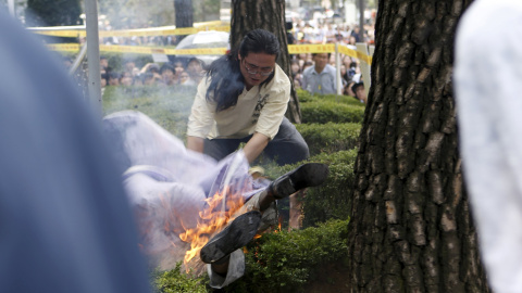 Un hombre intenta apagar las llamas de otro hombre (parte inferior) que se prendió fuego durante una manifestación contra Japón en Seúl, Corea del Sur.-REUTERS / Kim Hong-Ji