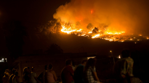 Un grupo de gente ve cómo el incendio avanza sin control en Las Manchas, al suroeste de la isla de La Palma. REUTERS/Borja Suarez
