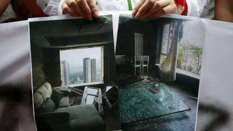 Una mujer muestra una imagen de cómo ha quedado su casa tras la explosión. La onda expansiva alcanzó a viviendas situadas a varios kilómetros a la redonda. REUTERS