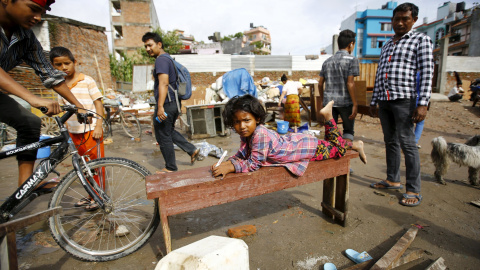 Una niña tumbada en un banco cerca de la orilla del río Bagmati después de las inundaciones causadas por las fuertes lluvias en Katmandú, Nepal 17 de agosto de 2015. REUTERS / Navesh Chitrakar