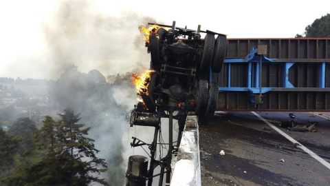 Un vehículo se incendia en la zona donde al menos nueve personas, entre ellas cuatro adultos y cinco niños, murieron ayer 16 de agosto, cuando el tractocamión en el que viajaban se impactó con una camioneta, en una autopista del occidental 
