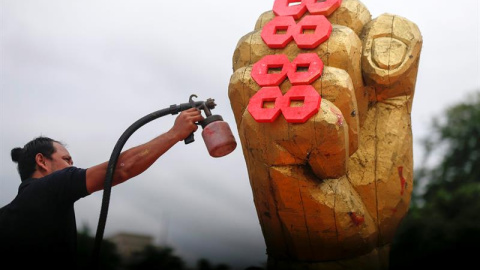 Un hombre pinta una escultura durante los preparativos para el 28 aniversario del "Levantamiento 8888" en Rangún (Birmania). El "Levantamiento 8888", como se conocen a las protestas que el 8 de agosto de 1988, terminó de manera sangrienta d