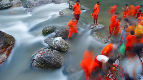 Un grupo de peregrinos hindús nepalíes, también conocidos como Bolboms, toman agua sagrada para rendir culto a Shiva, el dios de la creación y la destrucción, en el río Bagmati en Kathmandu, Nepal. EFE