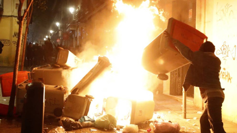 Contenedores incendiados en la calle Mesón de Paredes con la calle del Oso, en el barrio de Lavapiés de Madrid. | JAVIER LIZÓN (EFE)