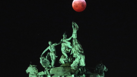 La luna vista a través de la cuádriga que corona el arco del Cinquantenaire en Bruselas, Bélgica. REUTERS/Yves Herman
