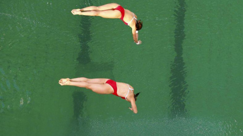Dos nadadoras realizan un salto durante la competición desarrollada en la piscina con el agua de color verde.- REUTERS Dos nadadoras realizan un salto durante la competición desarrollada en la piscina con el agua de color verde.- REUTERS