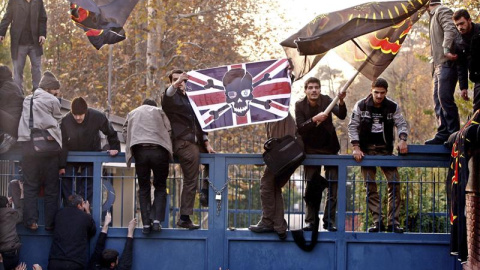 Varios estudiantes iraníes mientras intentan penetrar en la embajada británica durante una manifestación en Teherán, Irán. EFE/Abedin Taherkenareh