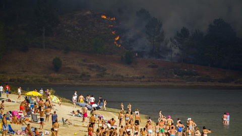 El incendio de Soutomaior ha llegado a la playa fluvial del río Verdugo ante la atenta mirada de sus vecinos, que disfrutaban de un baño/EFE
