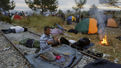 Un refugiado sirio reza sobre la vía férrea en la frontera entre Grecia y Macedonia, cerca del pueblo de Idomeni.- REUTERS Un refugiado sirio reza sobre la vía férrea en la frontera entre Grecia y Macedonia, cerca del pueblo de Idomeni.- REUTERS