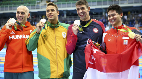 De izquierda a derecha, los nadadores Laszlo Cseh (Hundría), Chad Le Clos (Sudáfrica) y Michael Phelps (EEUU), con su medalla de plata en la final de 100 mariposa, junto al medalla de oro, Joseph Schooling (Singapur). REUTERS/Michael Dalder