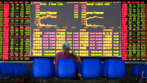 Una mujer observa los paneles con la información de la marcha de la bolsa, en Shanghai. REUTERS/Aly Song