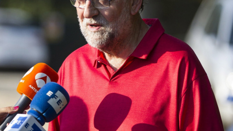El presidente del Gobierno en funciones, Mariano Rajoy, hace unas declaraciones alos medios tras tras finalizar su paseo matutino en la zona donde descansa estos días en la provincia de Pontevedra. EFE/Óscar Corral