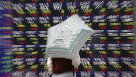 Un hombre observa una pantalla que muestra información bursátil en una calle en Tokio (Japón). El índice Nikkei de la Bolsa de Tokio cerró hoy con una subida de 579,73 puntos, un 3,26 por ciento, y se situó en las 18.386,43 unidades. El seg