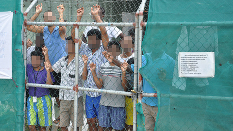 Refugiados miran desde la valla del centro de detención en la Isla de Manus. REUTERS Refugiados miran desde la valla del centro de detención en la Isla de Manus. REUTERS