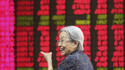 Una mujer sonríe al ver la información bursátil en la paNtalla de una oficina de corretaje en Pekín (China) hoy, 27 de agosto de 2015. EFE/Wu Hong