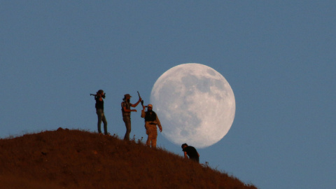 La armada libre del ejército sirio hace guardia encima de una colina mientras la luna se alza al fondo, en el sur de la ciudad de Nawa, Siria. REUTERS / Alaa Al - Faqir