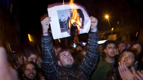 Manifestants cremen una fotografia del rei / EFE
