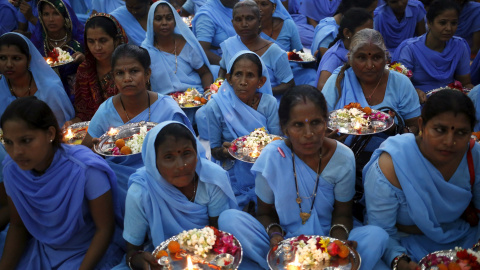 Mujeres hindúes sostienen platos decorados con elementos religiosos esperan para empatar " Rakhi " a los santos hindúes durante una función en Nueva Delhi. REUTERS
