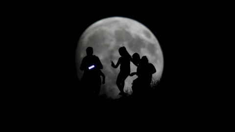 La silueta de un grupo de excursionistas se ve dibujada en la luna en Tijuana. REUTERS