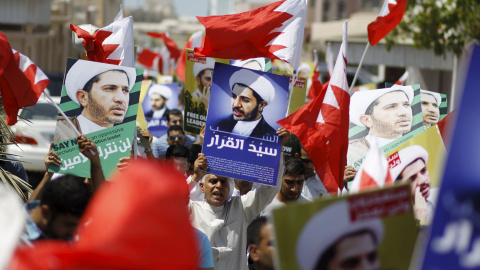 Los manifestantes sostienen banderas de Bahrein y pancartas con imágenes de Salman durante una manifestación después de las oraciones del viernes en la aldea de Diraz. REUTERS