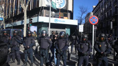 Agentes de la Policía Nacional protegen de los taxistas la sede del Partido Popular, situada en la calle Génova de Madrid. | Ricardo Rubio / Europa Press