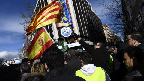 Un taxista con la bandera española y de la Comunidad Valenciana en la concentración frente a la sede del PP en la calle Génova. | PIERRE-PHILIPPE MARCOU / AFP