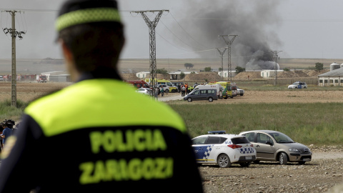 Un policía de Zaragoza y al fondo el humo que queda tras las explosiones en la empresa de pirotecnia./REUTERS/Luis Correas Un policía de Zaragoza y al fondo el humo que queda tras las explosiones en la empresa de pirotecnia./REUTERS/Luis Correas