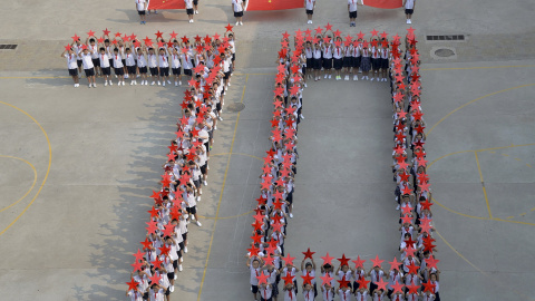 Estudiantes de un colegio de primaria forman el número "70" , con banderas nacionales chinas y estrellas rojas durante un acto de celebración del 70 aniversario de la victoria de la Guerra del Pueblo Chino de Resistencia contra la Agresión 
