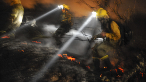 Tres brigadistas realizan labores de extinción ayer en el incendio forestal, registrado en Cualedro, en el sur de la provincia de Ourense, que ha quemado más de 2.000 hectáreas de terreno forestal. EFE/Brais Lorenzo