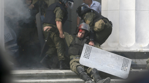 Un oficial de la guardia nacional herido se deja llevar por los compañeros en el edificio del parlamento en Kiev tras el ataque de este lunes, Ucrania, 31 de agosto de 2015./REUTERS / Valentyn Ogirenko