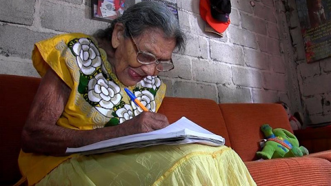 La mexicana Lupita Palacios escribe en un cuaderno.- EFE