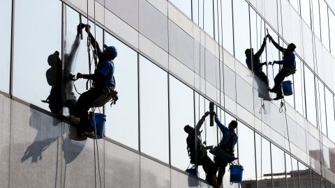 Varios trabajadores limpian los cristales de un edificio de oficinas en Washington, 1 de septiembre de 2015. REUTERS/Kevin Lamarque