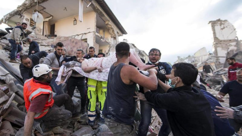 Una mujer herida es rescatada de entre los escombros de un edificio en Amatrice, en el centro de Italia/EFE