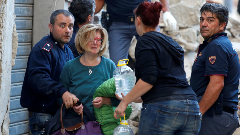 Una mujer es atendida por los equipos de rescate en Amatrice, tras el terremoto que ha sacudido el centro de Italia en la madrugada. REUTERS/Remo Casilli