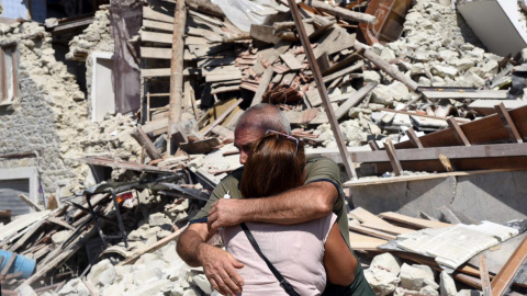 Dos lugareños se abrazan ante varias casas derrumbadas en Pescara del Tronto, cerca de la localidad de Arquata del Tronto, en la provincia de Ascoli Piceno, región de Marche, tras el terremoso en el centro de Italia. EFE/Crocchioni