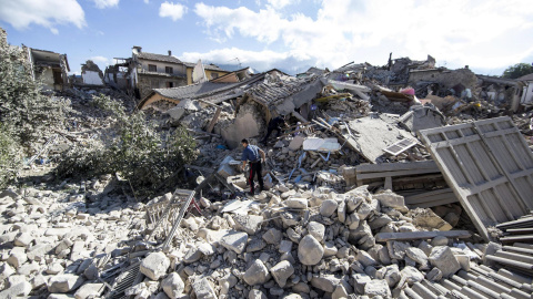Un carabinero busca supervivientes entre los escombros de un edificio derrumbado en Amatrice,  tras el terremoto que ha sacudido el centro de Italia en la madrugada. EFE/Massimo Percossi