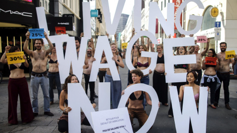 Activistas de "LKicing Wage Now" se quitan la ropa durante una manifestación en Bruselas (Bélgica) hoy. Exigen una mejora de las condiciones de trabajo y una paga justa para los trabajadores de la industria textil. EFE/Olivier Hoslet