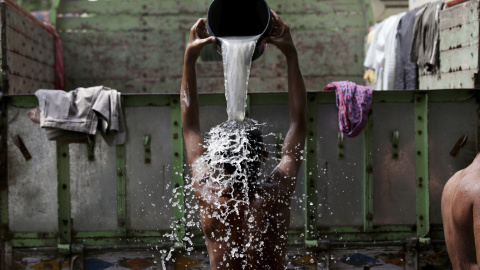 Conductores indios se duchan en Barabazar en Calcuta (India) durante una huelga general convocada por los sindicatos que protestan contra el partido gubernamental Bharatiya Janata Party (BJP) y su la reforma laboral hoy, 2 de septiembre de 