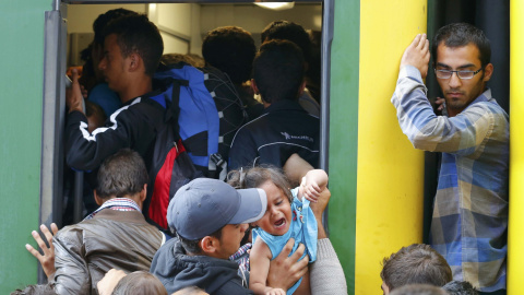 Cientos de refugiados intentan subirse a un tren en la estación de Keleti (Budapest). /REUTERS