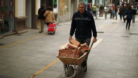 Un trabajador de la construcción traslada una carretilla con ladrillos por una calle de la localidad malagueña de Ronde. REUTERS/Jon Nazca Un trabajador de la construcción traslada una carretilla con ladrillos por una calle de la localidad malagueña de Ronde. REUTERS/Jon Nazca