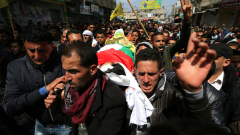 La multitud lleva el cadáver del agricultor palestino Omar Samour, asesinado la mañana de este viernes por las tropas israelíes cuando caminaba por sus tierras junto a la frontera de Israel con Gaza.- REUTERS / Ibraheem Abu Mustafa